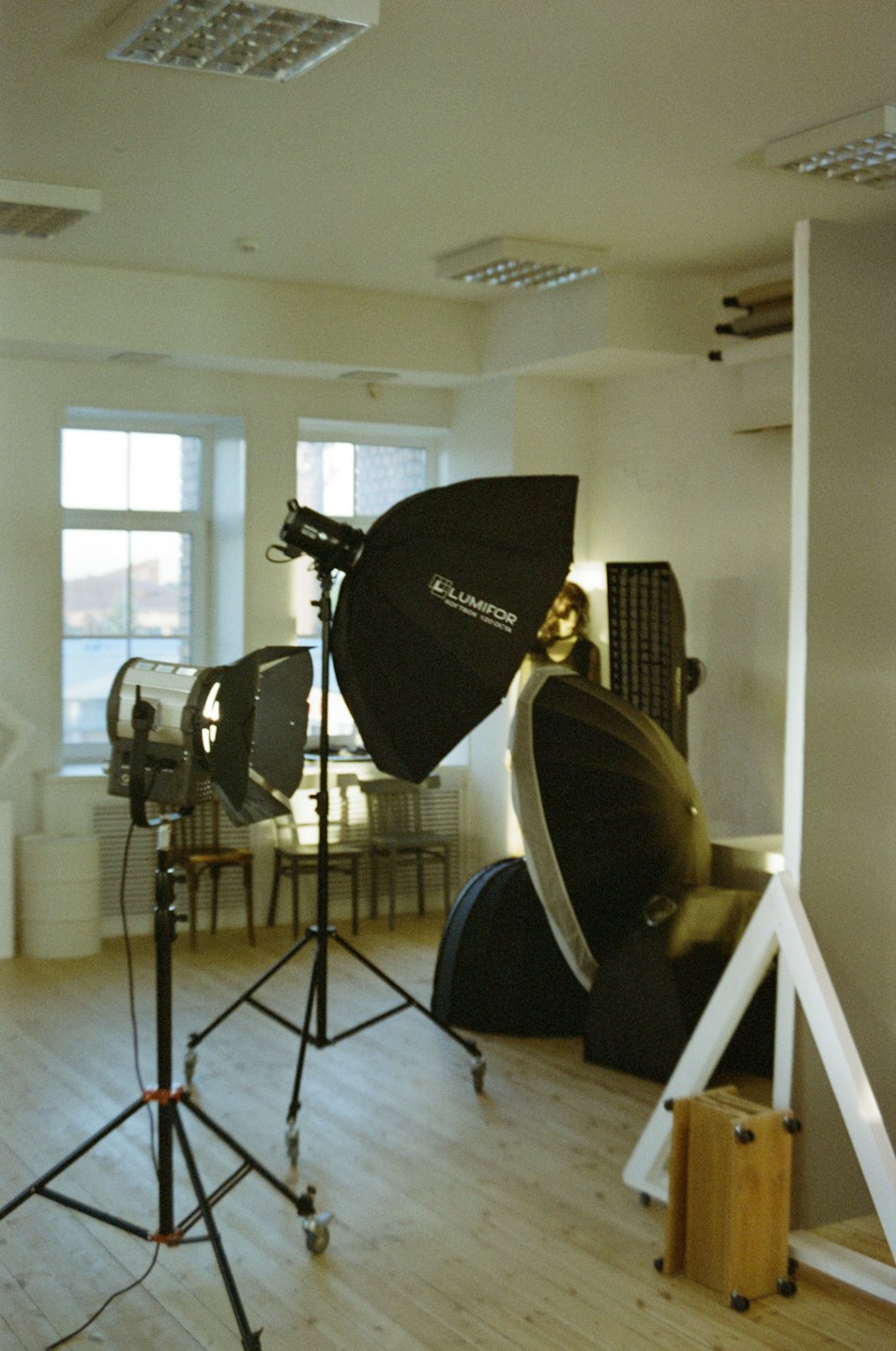 Attrezzatura professionale per l'illuminazione fotografica su un pavimento di legno da studio.