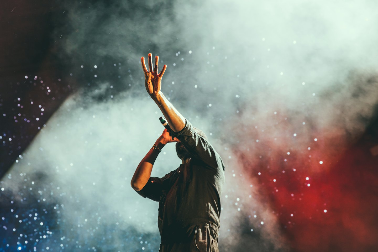 Artista su un palco fumoso con microfono in mano.